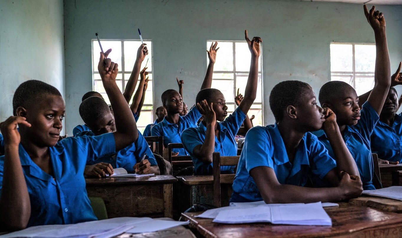 Students raise their hands during class